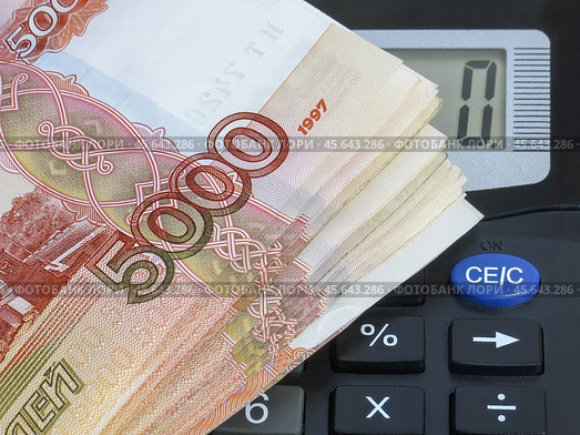 Бухгалтерский учет. Калькулятор и пачка денежных купюр номиналом 5000 рублей. Стоковое фото, фотограф Татьяна Т / Фотобанк Лори