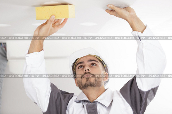 builder using sponge on plasterboard ceiling. Стоковое фото, агентство Ingram Publishing / Фотобанк Лори