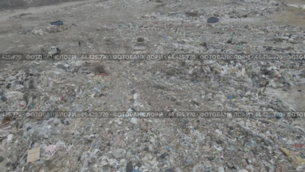 Bulldozer tractor pushes garbage from a mountain in a city dump. Стоковое видео, видеограф Игорь Соловьев / Фотобанк Лори