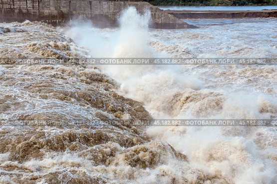Бурлящая вода, прошедшая сквозь плотину гидроэлектростанции ( сквозь водоводы ) Стоковое фото, фотограф Павел Просянов / Фотобанк Лори