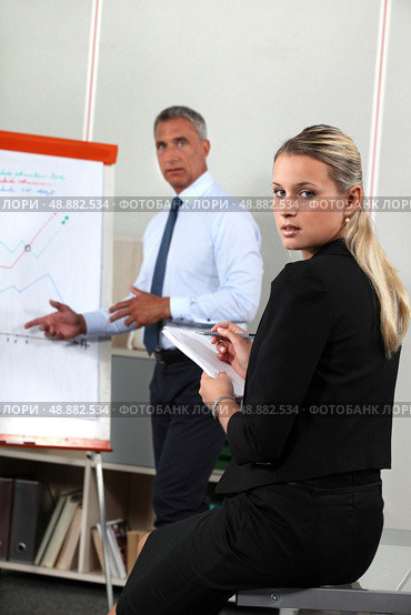 Business people looking at a flipchart. Стоковое фото, агентство Ingram Publishing / Фотобанк Лори