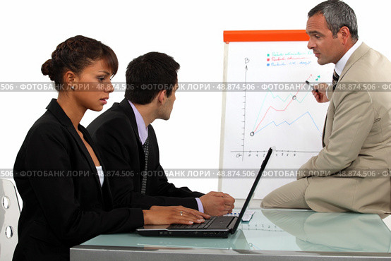 Business team discussing a flipchart. Стоковое фото, агентство Ingram Publishing / Фотобанк Лори