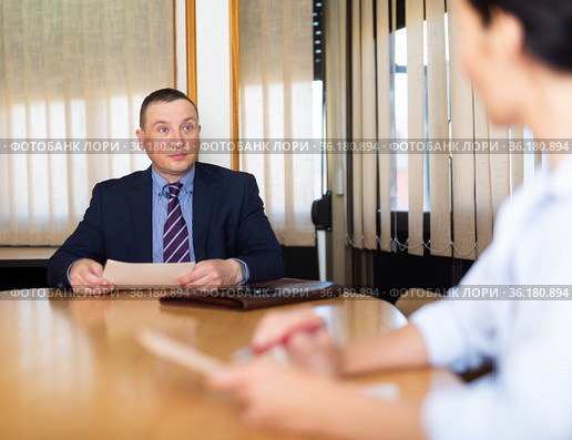 Businessman discussing partnership documents with female partner. Стоковое фото, фотограф Яков Филимонов / Фотобанк Лори