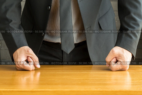 Businessman with clenched fist on the desk at office. Стоковое фото, агентство Ingram Publishing / Фотобанк Лори
