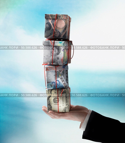 Businessman’s hand holding stack of gift boxes made of world currencies. 24316757. Стоковое фото, агентство Ingram Publishing / Фотобанк Лори