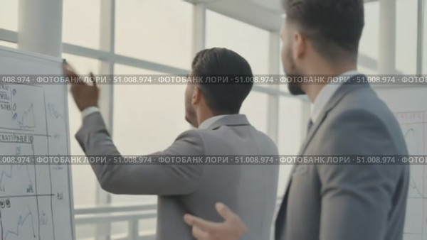 Businessmen discussing charts during meeting in bright office space. Стоковое AI-видео, аниматор Александра Рублева / Фотобанк Лори