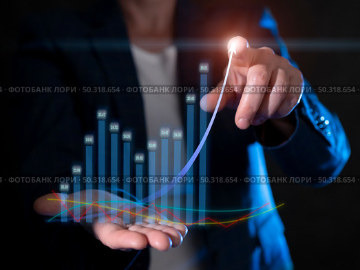 Businessperson analyzing growth trends using data visualization techniques in a professional setting during evening hours. Стоковое фото, фотограф Климов Денис / Фотобанк Лори