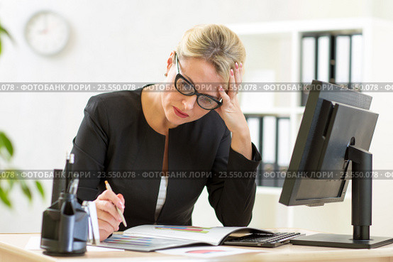 businesswoman looking at business papers in office. Стоковое фото, фотограф Оксана Кузьмина / Фотобанк Лори
