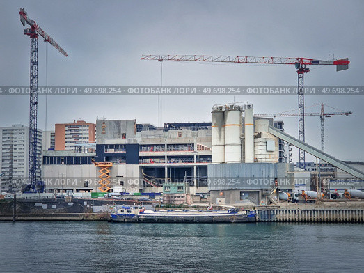 Busy building site near Seine river with cranes working and a barge on the water, Asnieres, Paris, France. Стоковое фото, агентство Ingram Publishing / Фотобанк Лори