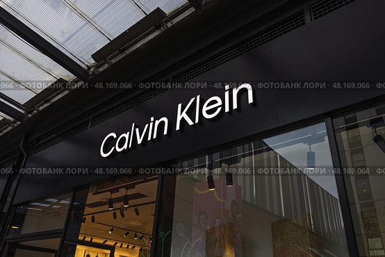 Calvin Klein store exterior with illuminated logo. London, UK, 17 March 2024. Редакционное фото, фотограф Zydrius Tartenis / Фотобанк Лори