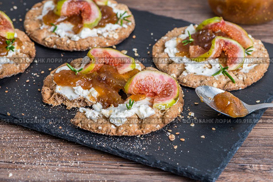 Canape or crostini with multigrain  crispread with cream cheese and fig jam on a slate board. Delicious appetizer ideal as an aperitif. Стоковое фото, агентство Ingram Publishing / Фотобанк Лори