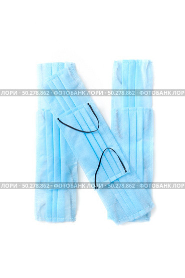 Capital letter N handmade from medical antibacterial protective blue face masks on a white background, copy space. Creative alphabet for making up new words.. Letter N made from protective medical masks on a white background. Стоковое фото, агентство Ingram Publishing / Фотобанк Лори