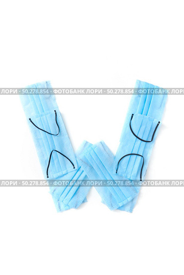 Capital letter W handmade from medical antibacterial protective blue face masks on a white background, copy space. Creative alphabet for making up new words.. Letter W made from protective medical masks on a white background. Стоковое фото, агентство Ingram Publishing / Фотобанк Лори