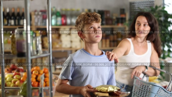 Capricious teenage boy wants to buy lot of sweets, but his mother does not allow him. Family quarrel in the supermarket. Стоковое видео, видеограф Яков Филимонов / Фотобанк Лори
