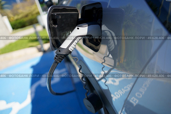Car charging its electric battery at one charging point for electric vehicles located on the street.. Refueling an electric car, an environment friendly alternative. Стоковое фото, агентство Ingram Publishing / Фотобанк Лори