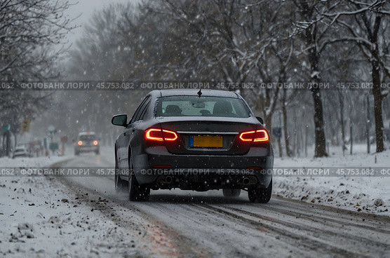 Car driving during winter snowstorm. Стоковое AI-изображение, AI-художник Александр Поташев / Фотобанк Лори
