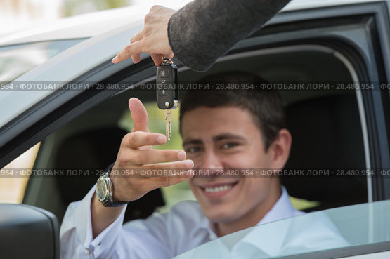 Car salesman handing over the keys for a new car to a young businessman. Стоковое фото, фотограф Kirill Kedrinskiy / Ingram Publishing / Фотобанк Лори