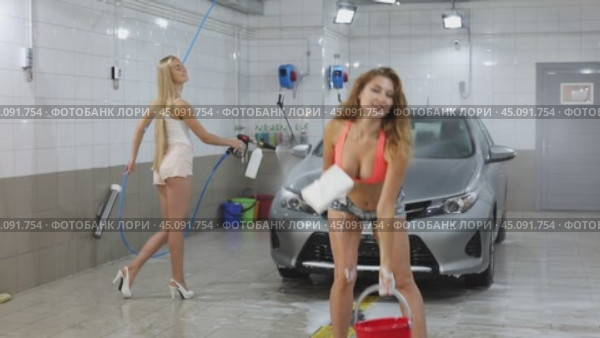 Car Wash. Three Sexy young beautiful girls in a car wash, indoor. Стоковое видео, видеограф Андрей Аркуша / Фотобанк Лори