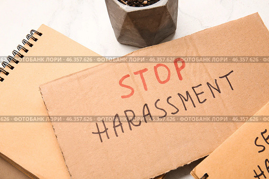 Cardboard with text STOP HARASSMENT on light background, closeup. Стоковое фото, фотограф Pixel_shot / Фотобанк Лори