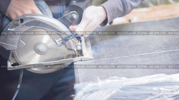 Carpenter cuts a wooden panel with a power tool. Стоковое фото, фотограф Дмитрий Попов / Фотобанк Лори