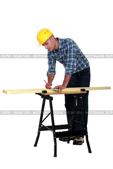 Carpenter measuring wood lath. Стоковое фото, агентство Ingram Publishing / Фотобанк Лори