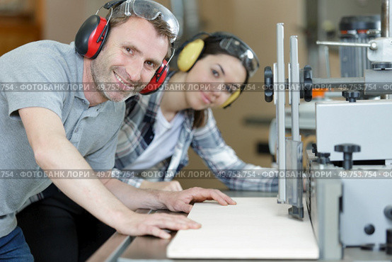 carpenter showing apprentice how to use sawing machine. Стоковое фото, агентство Ingram Publishing / Фотобанк Лори