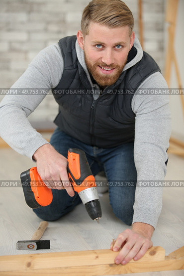 carpenter using cordless screwdriver on piece of wood. Стоковое фото, агентство Ingram Publishing / Фотобанк Лори