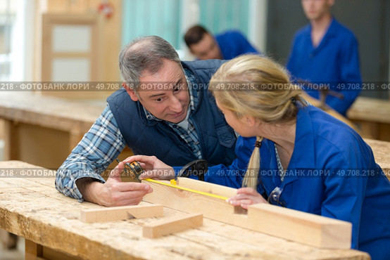 carpentry teacher instructing female student. Стоковое фото, агентство Ingram Publishing / Фотобанк Лори