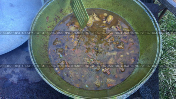 Cauldron with boiled meet, carrot and other ingredients, close up view pilaff cooking. Стоковое видео, видеограф Кекяляйнен Андрей / Фотобанк Лори