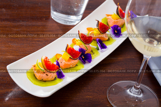 Ceviche from pickled red fish and cumquat a circle of kiwi, with figs at plate. Стоковое фото, фотограф Яков Филимонов / Фотобанк Лори
