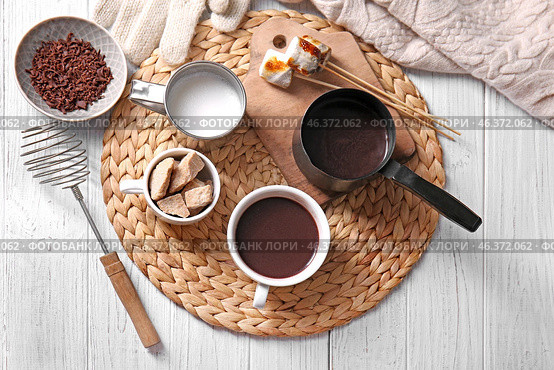 Cezve and cup of hot chocolate with ingredients and marshmallows on wicker mat. Стоковое фото, фотограф Pixel_shot / Фотобанк Лори