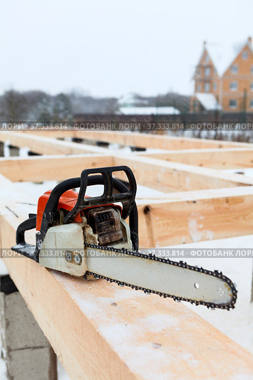 Chainsaw carpenter tool for building a frame house at winter season. Стоковое фото, фотограф Кекяляйнен Андрей / Фотобанк Лори