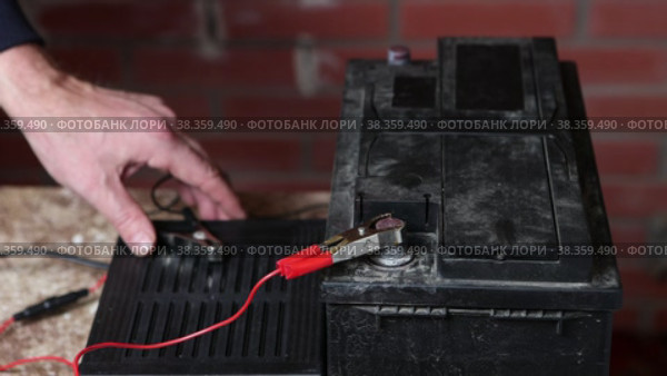 Charge car batteries, hooking up battery charger with alligator clip. Стоковое видео, видеограф Владимир Григорьев / Фотобанк Лори