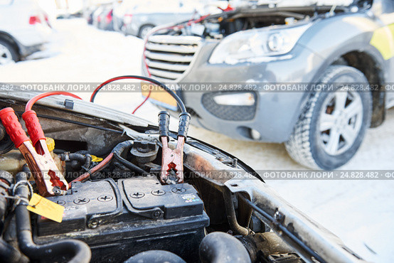 Charging automobile discharged battery by booster jumper cables at winter. Стоковое фото, фотограф Дмитрий Калиновский / Фотобанк Лори