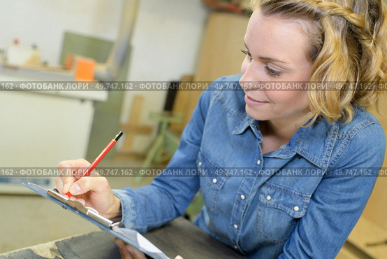 charismatic technician taking notes in the workshop. Стоковое фото, агентство Ingram Publishing / Фотобанк Лори