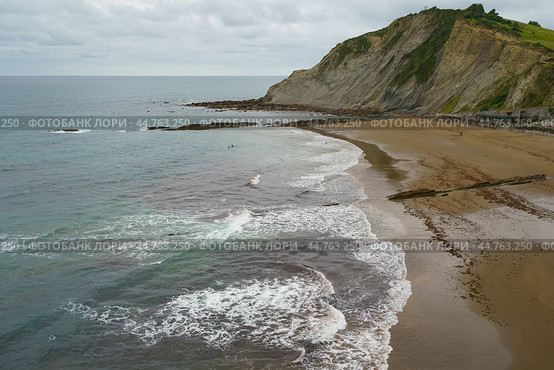 Charming Zumaia Itzurun beach. Steeply-tilted layers of flysch in Zumaia. Atlantic ocean surf in Basque Autonomous Community  in day in Bay of Biscay. View from above / top view. Стоковое фото, фотограф YuryKara / Фотобанк Лори