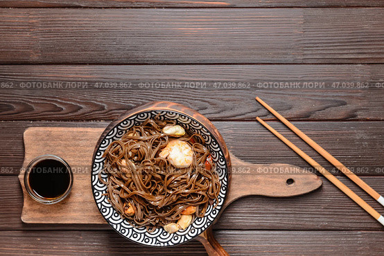 Чаша с вкусной лапшой соба и морепродуктами на деревянном фоне. Стоковое фото, фотограф Pixel_shot / Фотобанк Лори