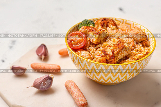 Чаша с вкусным рисом, курицей и овощами на белом фоне. Стоковое фото, фотограф Pixel_shot / Фотобанк Лори
