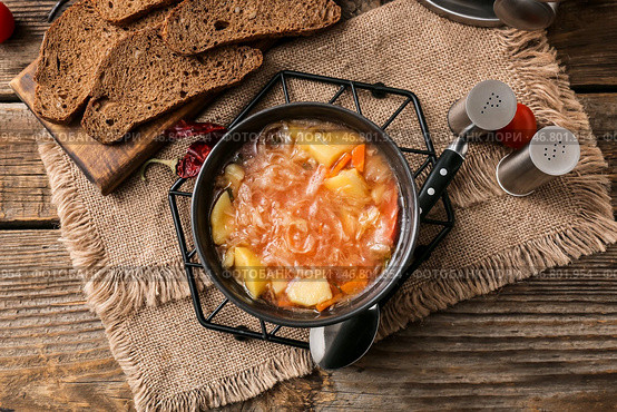 Чаша с вкусным супом из квашеной капусты и ломтиками свежего хлеба на деревянном фоне. Стоковое фото, фотограф Pixel_shot / Фотобанк Лори