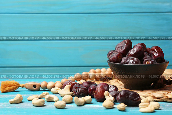 Чаша со вкусными финиками на деревянном столе. Стоковое фото, фотограф Pixel_shot / Фотобанк Лори