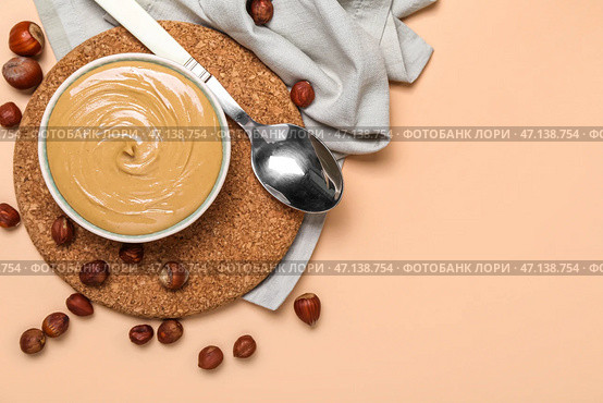Чаша вкусного орехового масла на цветном фоне. Стоковое фото, фотограф Pixel_shot / Фотобанк Лори