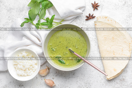 Чаша вкусного зеленого куриного карри и ингредиентов на светлом фоне. Стоковое фото, фотограф Pixel_shot / Фотобанк Лори