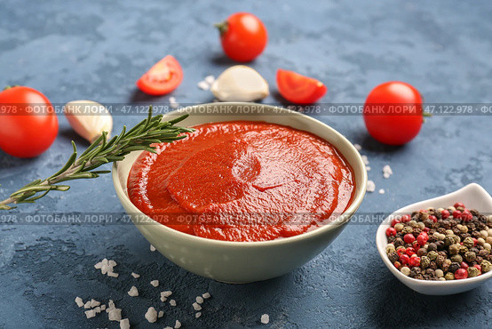 Чаша вкусной томатной пасты, розмарина, перца и зубчиков чеснока на синем фоне гранж. Стоковое фото, фотограф Pixel_shot / Фотобанк Лори