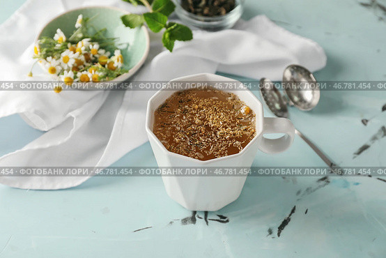 Чашка вкусного ромашкового чая на светлом столе. Стоковое фото, фотограф Pixel_shot / Фотобанк Лори