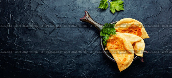 Chebureks, fried crescent-shaped cakes with meat filling. Copy space. Delicious chebureks, space for text. Стоковое фото, агентство Ingram Publishing / Фотобанк Лори