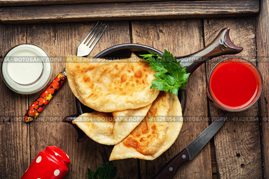 Chebureks, fried crescent-shaped cakes with meat filling. Fried pies. Appetizing meat pie or chebureks. Стоковое фото, агентство Ingram Publishing / Фотобанк Лори