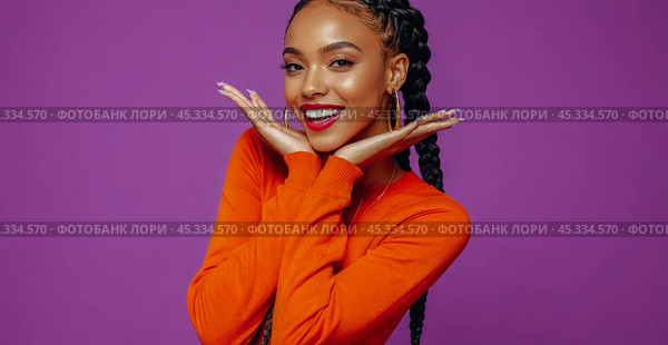 Cheerful Young African American Woman with Long Braids Wearing Vibrant Orange Top Posing for Advertisement, Exuding Warmth and Enjoyment. Стоковое AI-изображение, AI-художник Павел Муравьев / Фотобанк Лори