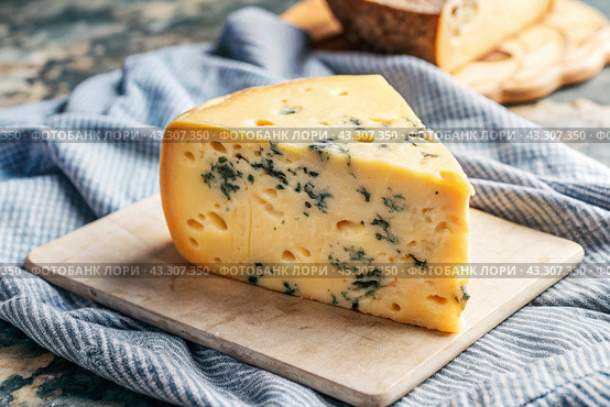 Cheese with mold, a slice of cheese with mold door blue or Roquefort on a cutting board. Delicious food. Стоковое AI-изображение, AI-художник Photojuli / Фотобанк Лори