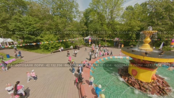 Cherepovets, Russia - May 27, 2023, Families with children at a town festival walk around the fountain in the summer heat. The park is decorated with flags. FPV Aerial Drone Shot. Редакционное видео, видеограф Даниил Хабаров / Фотобанк Лори