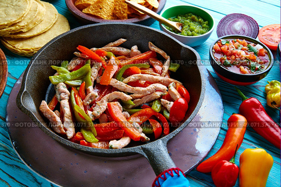 chicken fajitas in a pan with sauces chili and sides Mexican food. Стоковое фото, агентство Ingram Publishing / Фотобанк Лори